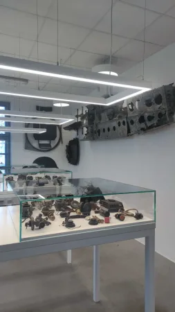 Skleněná vitrína s vystavenými starými leteckými motory a přístroji uvnitř muzea letectví.