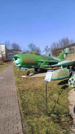 Zelený kamuflovaný stíhací letoun MiG s číslem 606 na venkovní expozici muzea.