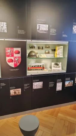 Muzejní expozice s modelem červené tramvaje, jihlavským erbem a historickými snímky
