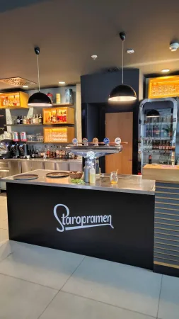 Barový pult se značkou Staropramen v moderně zařízeném restauračním baru