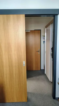 Posuvné dřevěné dveře oddělující chodbu hotelového pokoje