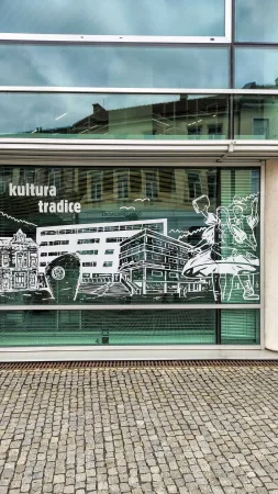 Skleněná výloha informačního centra s kresbou a nápisem kultura tradice
