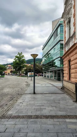 Vsetínské náměstí se skleněnou budovou informačního centra a dlažbou