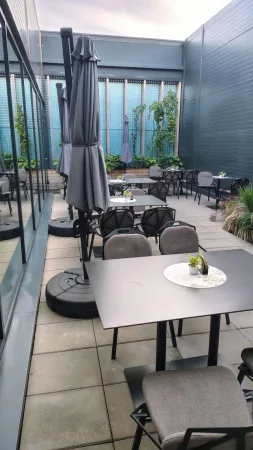 Prázdná terasa restaurace ve Vsetíně s deštníky a stoly večer
