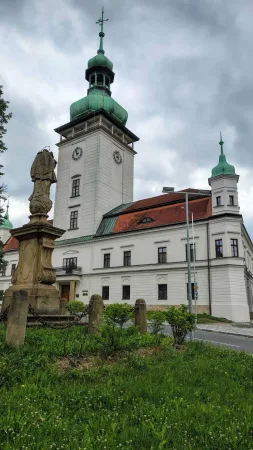 Bílý vsetínský zámek s věží se zelenou měděnou kopulí