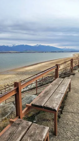 Holzbank am Geländer mit Blick auf den See Liptovská Mara und die Tatra