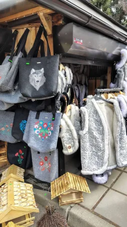 Filztaschen mit Stickereien und Schafspelze an einem Freiluftstand