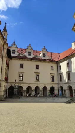 Nádvoří Průhonického zámku s cyklisty a věžičkou