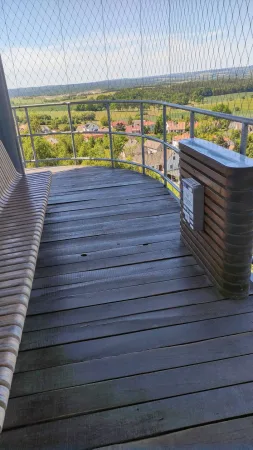 Dřevěná vyhlídková plošina rozhledny Hýlačka s lavicí a sloupkem s cedulkou