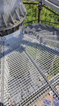 Kovové ocelové schody a mřížové stupně točitého schodiště rozhledny Vysoká při pohledu shora