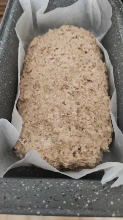 Massa crua de pão caseiro numa forma forrada com papel vegetal