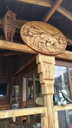 Geschnitztes Holzschild mit Tieren über dem Gebäudeeingang