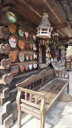 Holzbank und eine Wand mit bemalten Herzen bei der Salaš Krajinka