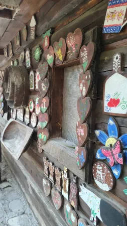 Volkstümliche bemalte Verzierungen und Herzen auf einer Holzwand der Salaš Krajinka