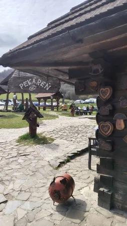 Eingang zur Bäckerei der Salaš Krajinka mit Holzverzierungen und einem Schwein