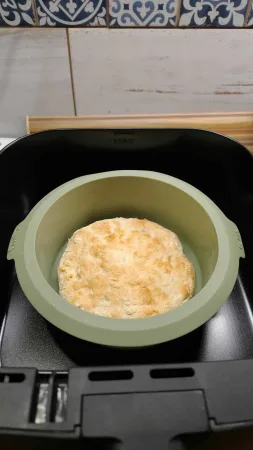 Předpečený špaldový korpus pizzy v zelené silikonové formě Lékué uvnitř koše horkovzdušné fritézy