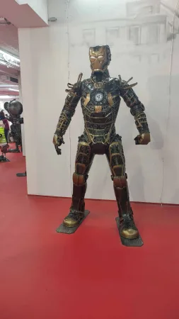 Kovová socha Iron Mana v brnění se zlatými detaily.