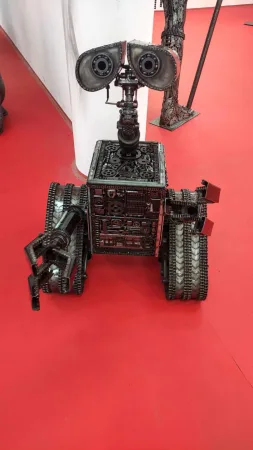 Kovová socha robota Číslo 5 poskládaná z pásů a ozubených kol.