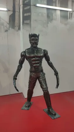 Kovová socha Wolverina s vysunutými drápy z kovového šrotu.