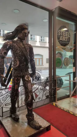 Vstup do Steel Art Musea v Praze s kovovou sochou bojovníka u dveří.
