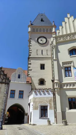 Věž s hodinami, průchod s obloukem a štíty historických domů v centru Tábora