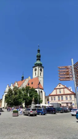 Žižkovo náměstí v Táboře s kostelní věží, zaparkovanými auty a směrovkami k památkám