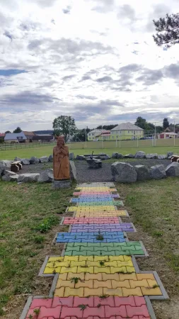 Duhová dlážděná cesta vedoucí k dřevěné soše vikinga ve Vendolí