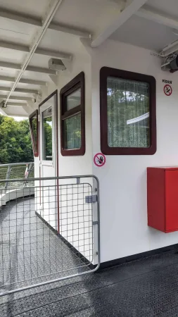 Boční chodba lodi s okny kormidelny a výhledem na hladinu.
