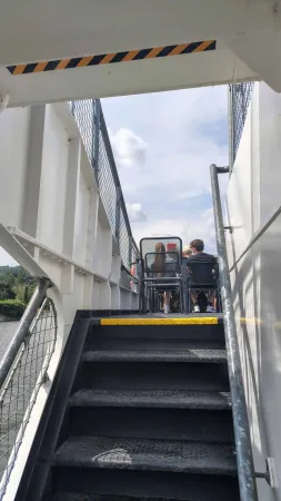 Schodiště vedoucí na horní otevřenou palubu výletní lodi na přehradě.
