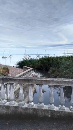 Kamenná balustráda s výhledem na přístav a plachetnice na Balatonu