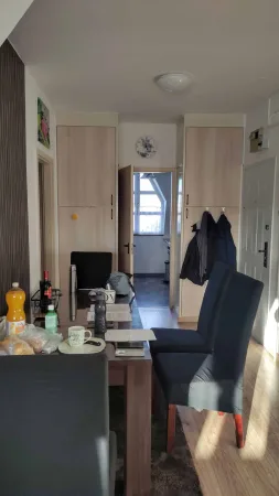 Jídelní kout s kuchyňskou linkou a průhledem do chodby apartmánu