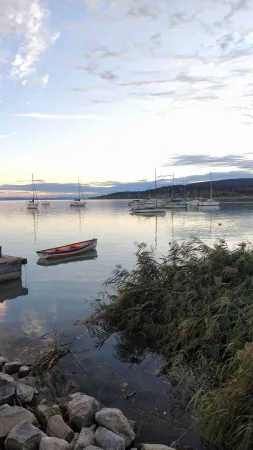 Lodičky zakotvené na Balatonu při klidném soumraku s odrazem v hladině