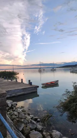 Plachetnice zakotvené na Balatonu při krásném soumraku s odrazem mraků