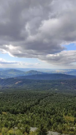Vue depuis le sommet du Ještěd sur les collines boisées sous des nuages dramatiques
