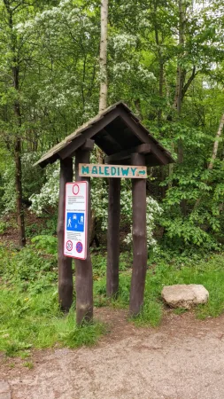 그루뎩 공원 입구 녹색 숲에 세워진 'Malediwy' 나무 표지판
