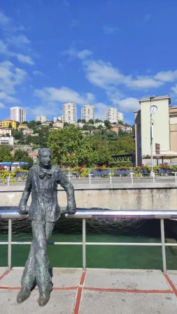 Socha spisovatele Kamova opřeného o zábradlí u řeky Rječiny v Rijece