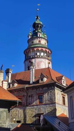 Detailní pohled na barevnou renesanční zámeckou věž s galerií v Českém Krumlově