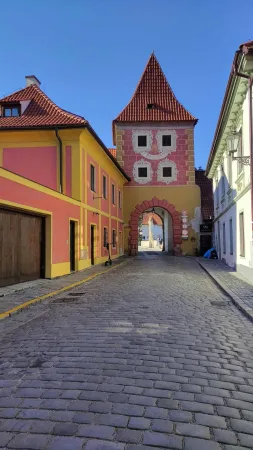 Barevná ulička vede k Budějovické bráně se sluneční malbou usměvavého slunce