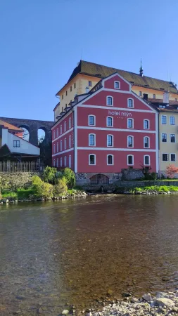 Červený Hotel Mlýn v historické budově mlýna na břehu Vltavy