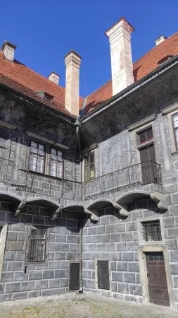 Renesanční nádvoří zámku s vysokými komíny a arkádovým balkonem v Českém Krumlově