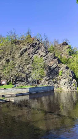 Skalnatý útes nad řekou Vltavou s odpočinkovou zónou a lavičkami