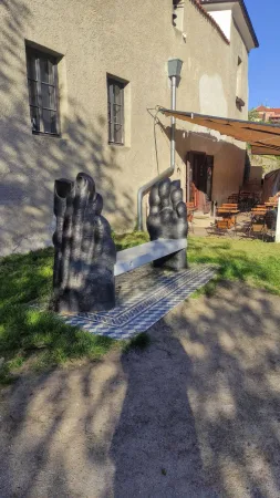 Netradiční kamenná lavička ve tvaru chodidel před kavárnou v Krumlově