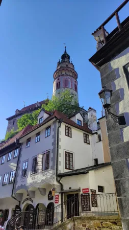 Úzká ulička s výhledem na barevnou zámeckou věž v Českém Krumlově