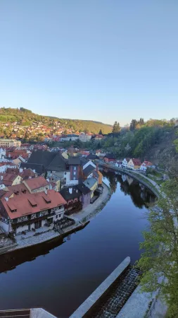 Večerní panorama zákrutu řeky Vltavy s jezem a starobylým městem