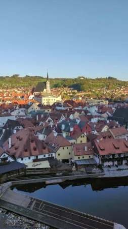 Malebné historické centrum Českého Krumlova s kostelní věží a řekou Vltavou za soumraku