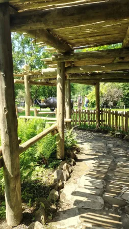 Eine Holzpergola mit Steinweg im grünen Park des Zoos Lešná