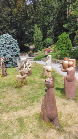 Abstraktní kamenné sochy rozmístěné na trávníku botanické zahrady