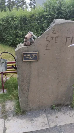 Kámen přání s plyšovým medvídkem, na který návštěvníci píší svá přání