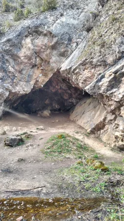 Primer plano de la entrada a una cueva en una maciza pared rocosa