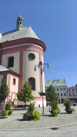 Zaoblená apsida kostela s kulatým oknem na náměstí v Hranicích